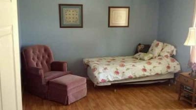 Cozy resident room with floral bedding and chair