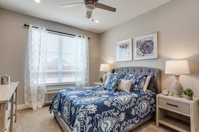 A cozy resident bedroom with floral decor and natural light
