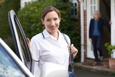 Homecare staff assisting a resident outdoors.