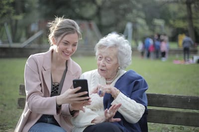 Young woman showing a smartphone to an elderly woman