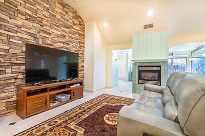Cozy lounge area with a stone wall and TV