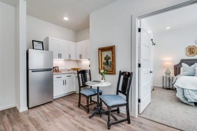 Cozy interior view of a resident's suite with kitchen and seating area