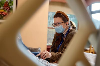 Staff member assisting a resident in a cozy indoor setting