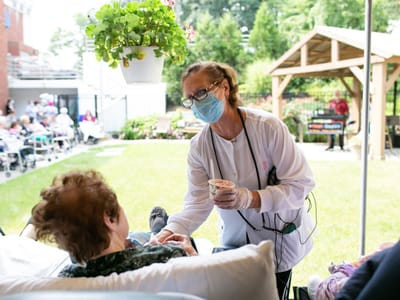 A caregiver interacting with a resident outdoors