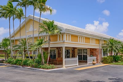 Exterior view of a senior living facility with palm trees