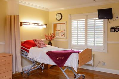 A cozy resident bedroom with a hospital bed and decorations