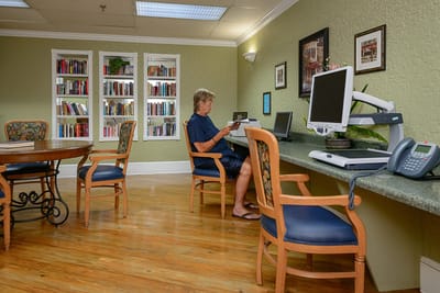 Resident reading in a cozy common area with bookshelves