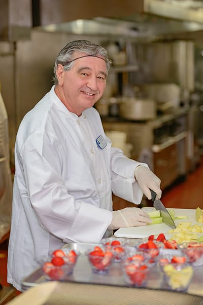 Chef preparing fresh fruit in the facility kitchen
