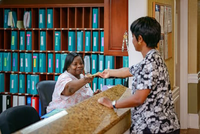Staff assisting a resident at the reception desk