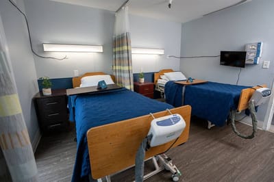 A shared resident room with two beds and furnishings