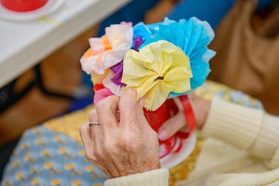 A resident creating paper flower crafts during an activity.