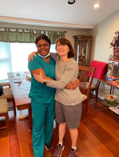 Staff member and resident sharing a warm embrace in a common area