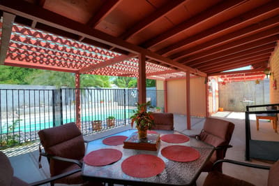 Outdoor seating area with a pool in the background