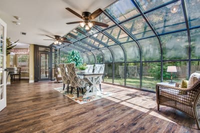 A bright sunroom with dining table and plants
