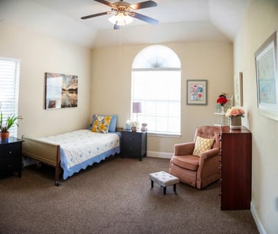 Cozy private resident room with a bed and chair