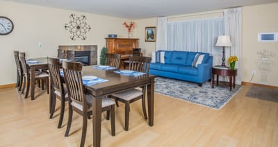 A bright dining area with tables and a sofa
