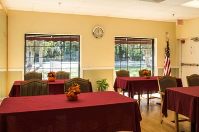 Bright common area with tables and floral arrangements