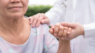 A caregiver holding hands with a senior resident
