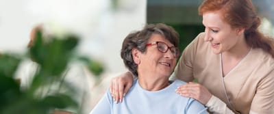 A caregiver smiling with a resident in a warm setting