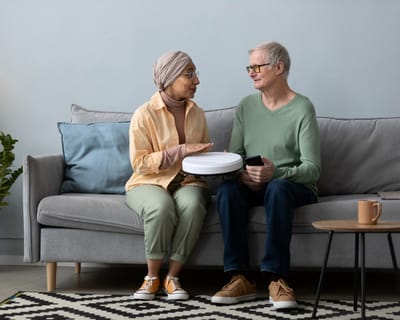 Two residents engaging with technology in a cozy living room