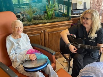 Resident participating in a music activity with staff