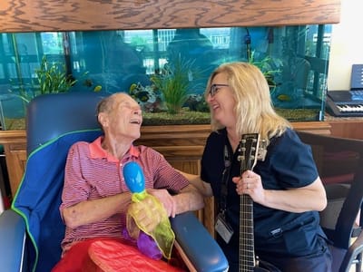 Staff member engaging with a resident in an activity room