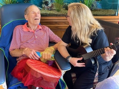 Resident participating in a music activity with staff member
