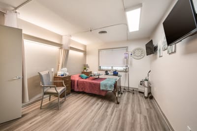 Private resident room with medical equipment and a bed