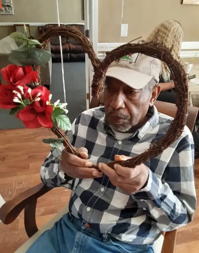 Resident enthusiastically holding a flower decoration