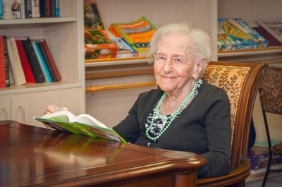 Elderly resident reading a book in a cozy interior