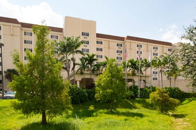 Exterior view of Life Care Center at Inverrary amidst greenery
