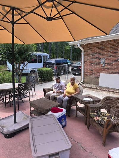 Residents enjoying time together outdoors under an umbrella