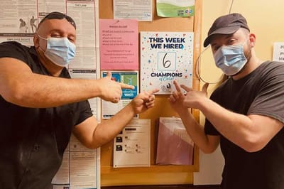 Staff celebrating hiring new team members on bulletin board