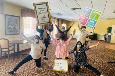 Staff celebrating in a common area with signs and decorations