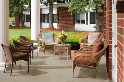 Outdoor seating area with wicker chairs and flowers