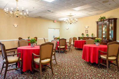 Bright common area with round tables and floral arrangements