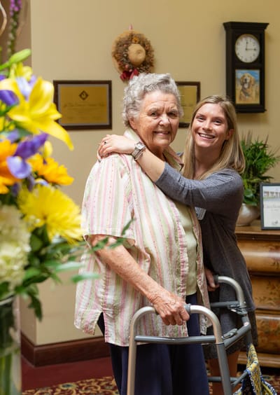 Resident and staff member sharing a smile in a common area