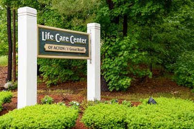 Facility sign surrounded by greenery