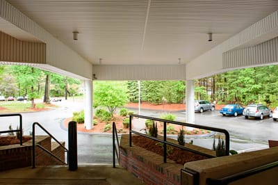 Entrance view with garden and parking area visible