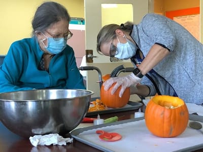 Residents participating in a pumpkin carving activity