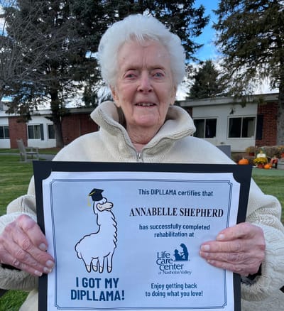 Resident holding a diploma in an outdoor area