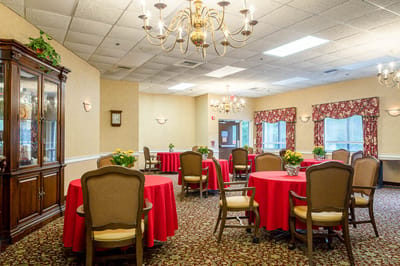 Bright dining room with red tables and floral decorations