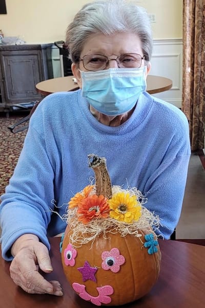 Resident decorating a pumpkin during an activity