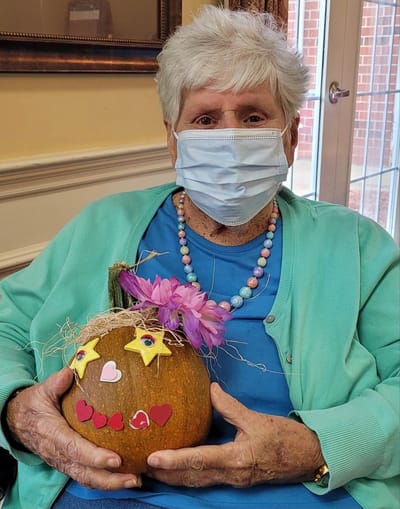 Resident creating a decorated pumpkin.