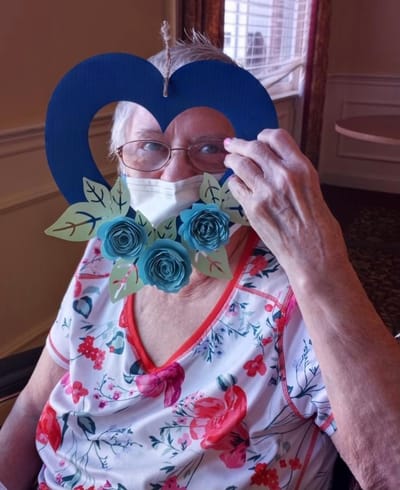 Resident holding a floral decoration in a cheerful room