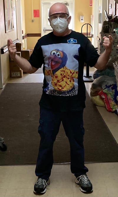 Staff member in a fun shirt posing in the hallway