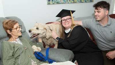 Residents and a graduate celebrating together with a dog