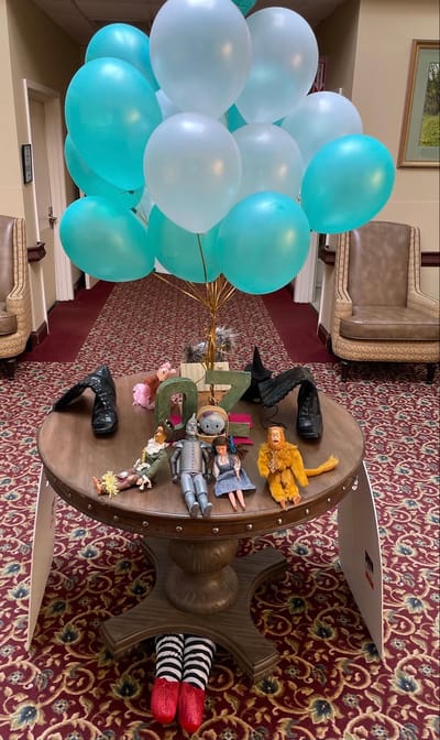Decorative table display with balloons and toys in a lobby