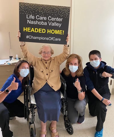 Residents and staff celebrating with a sign