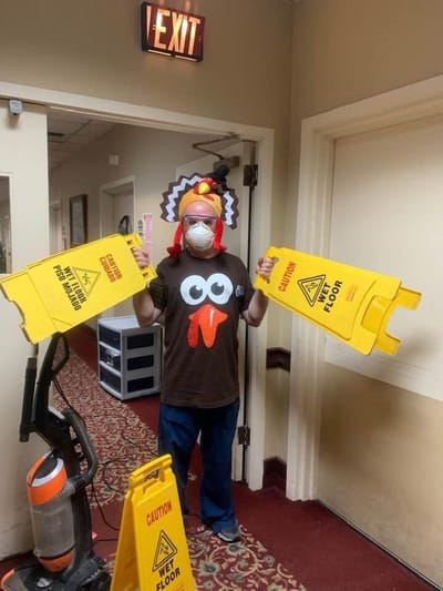 Staff member in a fun costume with caution signs